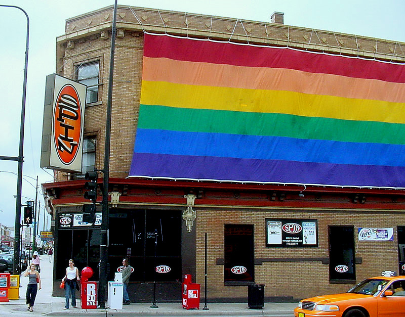 Large Pride Flag hanging on the side of Spin bar in Northalsted community formerly known as Boystown