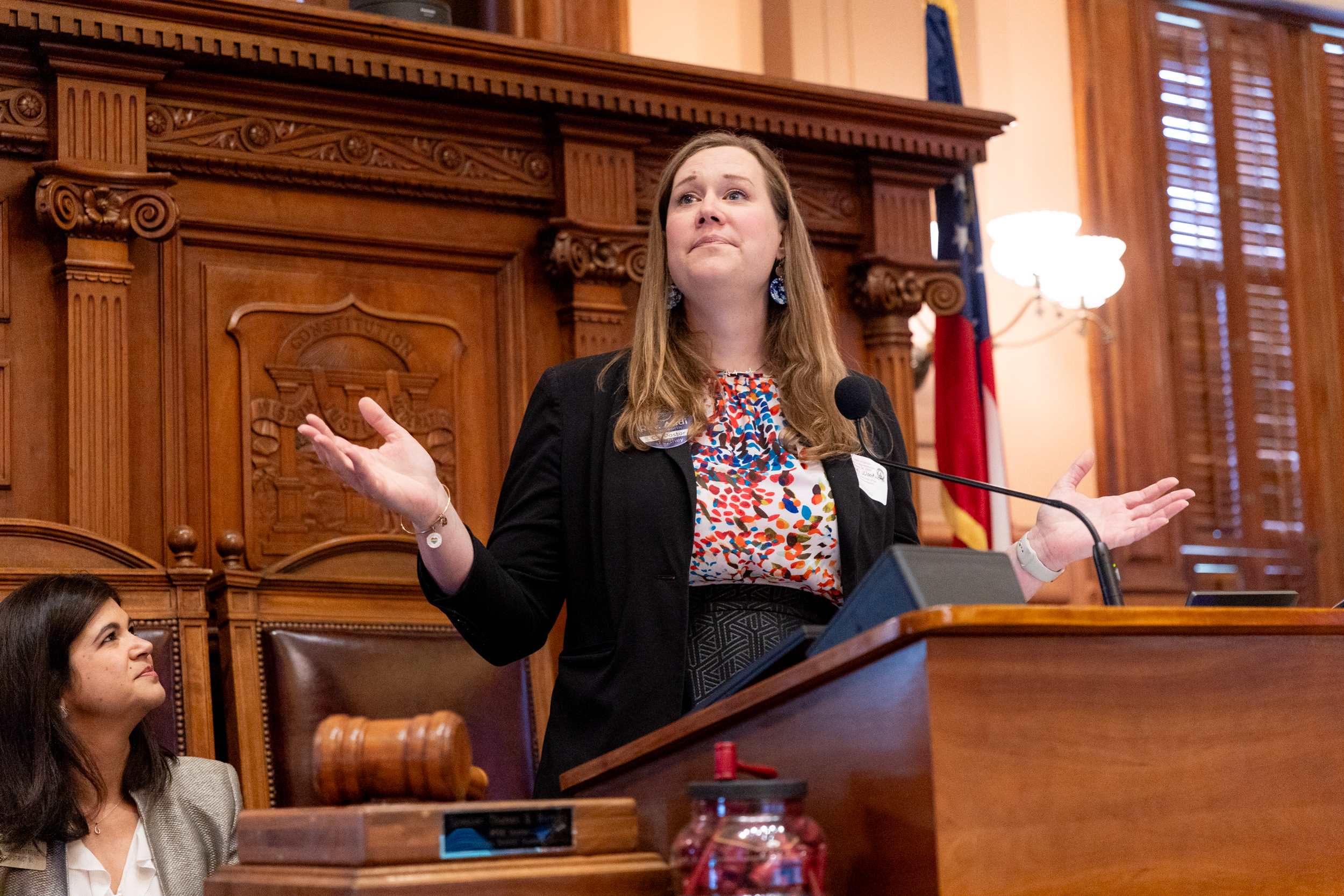 Woman giving speech behind wooden podium